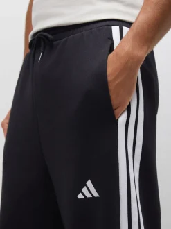 Noir - Pantalons à jambe large en polaires à trois rayures adidas Essentials